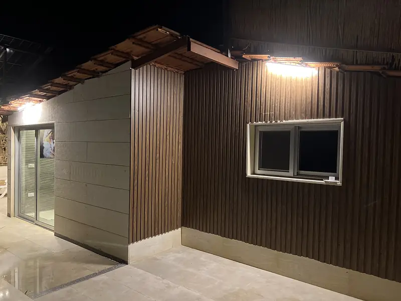 The chalet's timber exterior lit at night