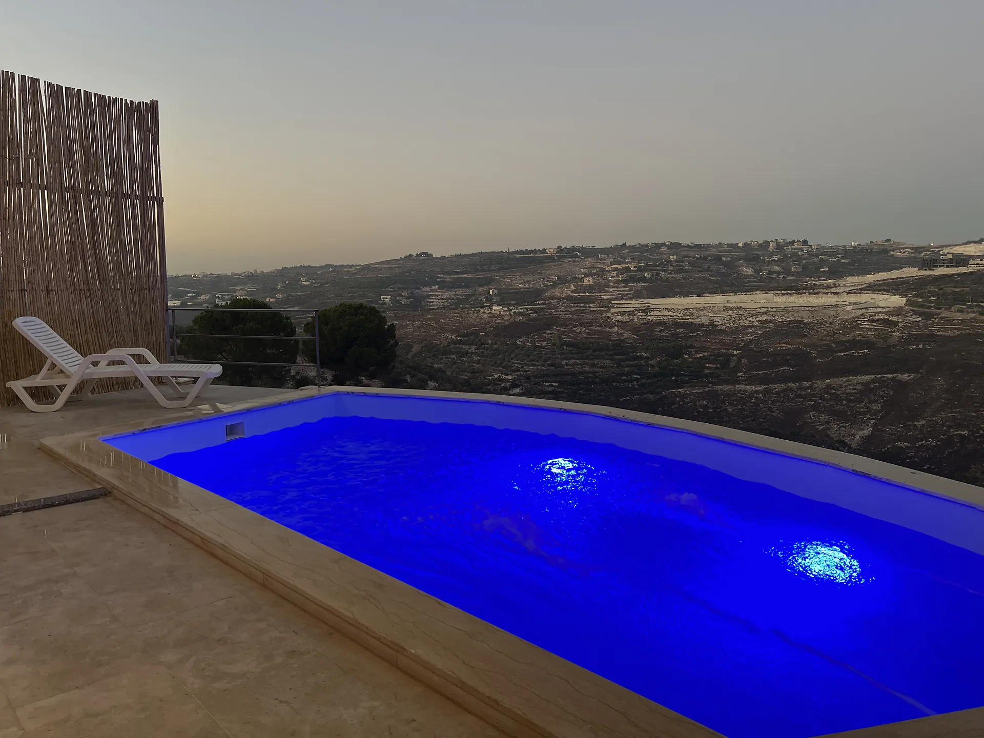 The pool lit at dusk, with the whole valley beyond it