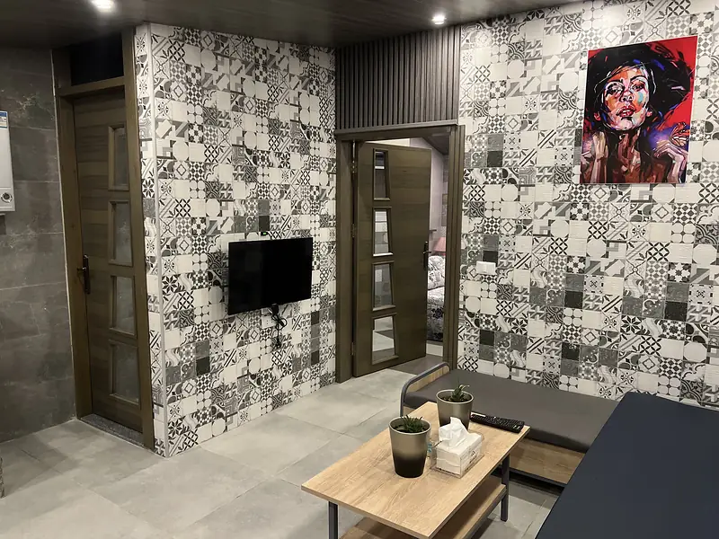 Seating and the smart TV against the patchwork tile